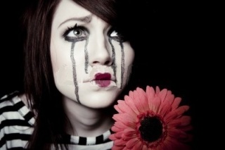 8945766-un-clown-triste-mime-feminin-avec-une-fleur-rouge